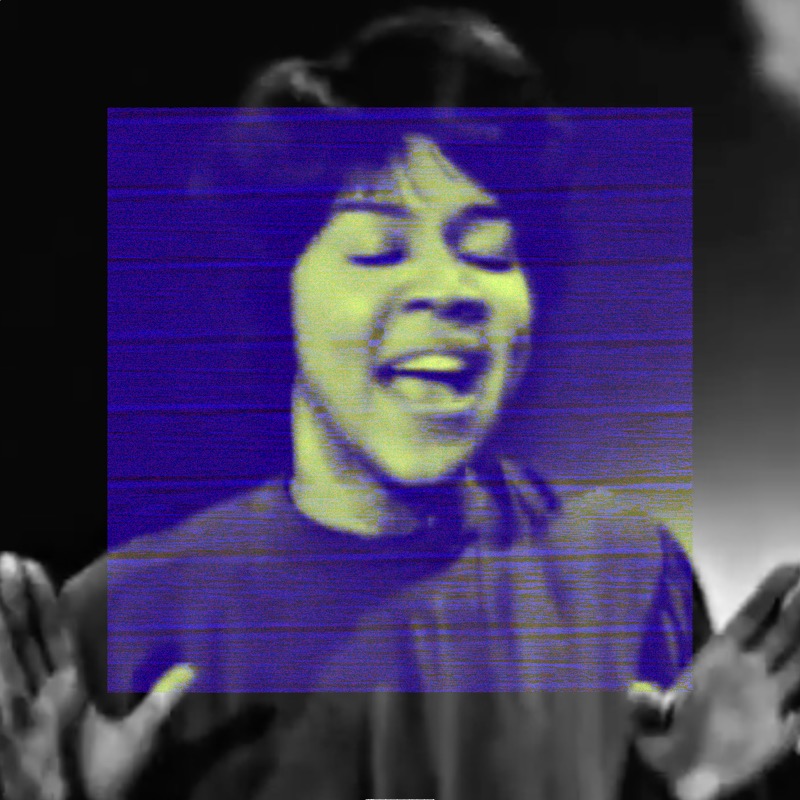 A close-up of Mavis Staples singing with her mouth open, eyes closed, hands raised open at shoulder height. The outer image is dark grayscale. The additive channel operations create a large deep indigo-blue square covering the center, with yellow-green coloration visible on her face and skin within it. The contrast between the blue field and warm yellow-green undertones gives the image an otherworldly quality.