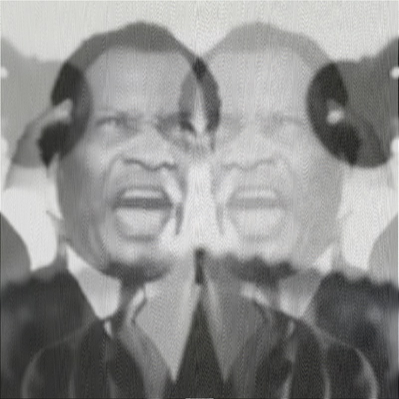 A black and white close-up of Paul Robeson's face with his mouth wide open in song, doubled horizontally across the frame. The mirror-x keymap creates a bilateral diptych — his face is reflected so two nearly identical open-mouthed singing faces appear side by side, giving the grainy television image an uncanny symmetry.